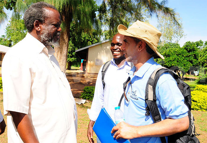 John Travis meets a local leader at the launch of the water pump as Olobo looks on