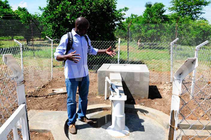 Julius Olobo, the area manager Drop in the Bucket teaches a blind pupil how to use the newly installed water-borne toilets at Madera School for the Blind