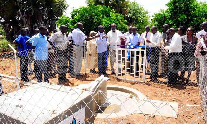 Officials of Drop in the Bucket show the water source that operates on solar that was installed for the blind school. Photo by Eddie Ssejjoba