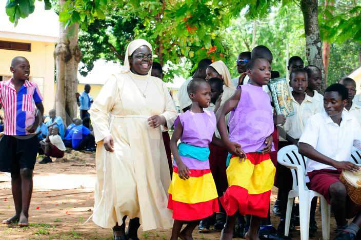 The head teacher, Sister Kevin nasirumbi dances with someof the pupils at the launch of a solar water system