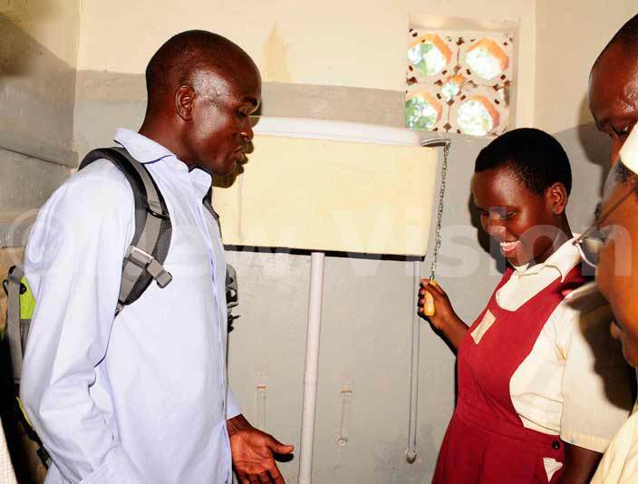 A pupil plays an acordian at the function to commission a water system for the blind children at madera in Soroti