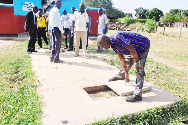 Water and sanitation officers examining a septic tank for the flush toilets of Hope Junior School in Soroti district.