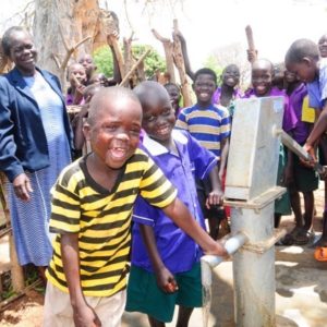 Children stand by well at Oriau Primary School in Uganda.