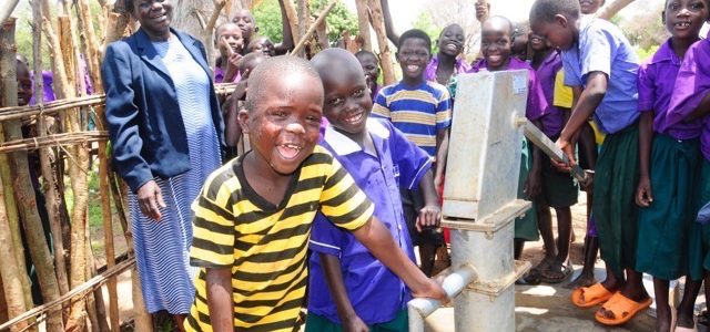 Children stand by well at Oriau Primary School in Uganda.