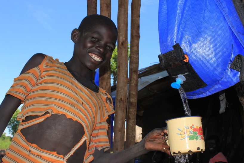 World Refugee Day - A South Sudanese refugee child getting clean water from a Pack H2O water backpack in Uganda