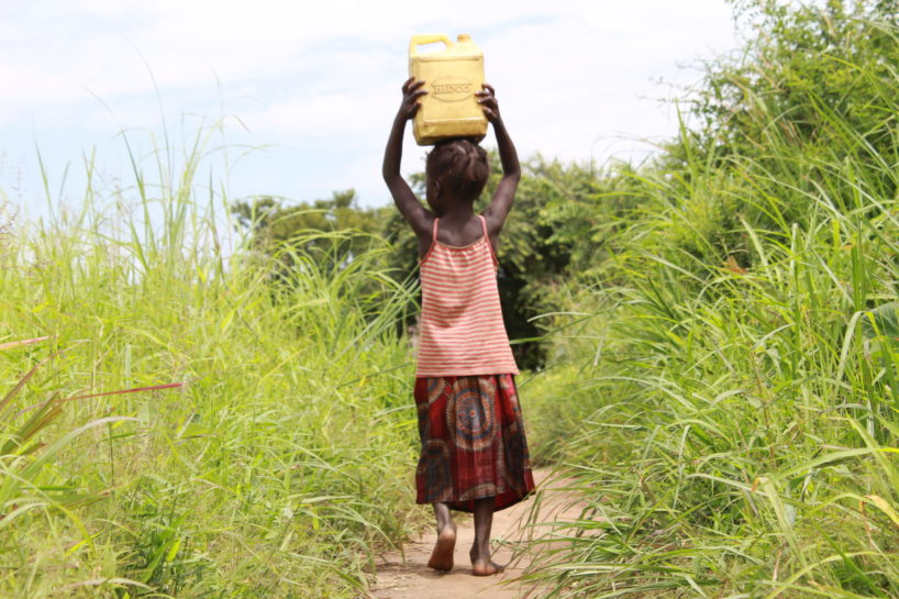 Young girl with water jug on her head in Uganda showing importance of World Water Week