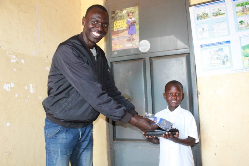 Drop in the Bucket Employee gifts a young student a new pair of shoes in Uganda