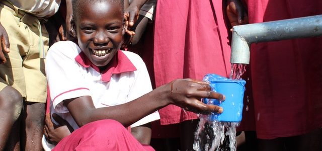 Girl drinking clean water from a new well drilled by Drop in the Bucket at the Busia Primary School in Koboko, Uganda.