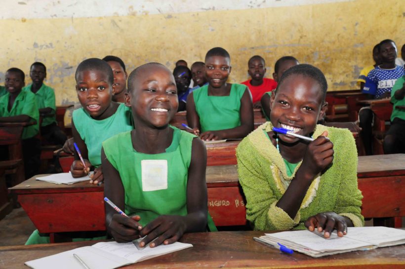 Students in Uganda smiling in class