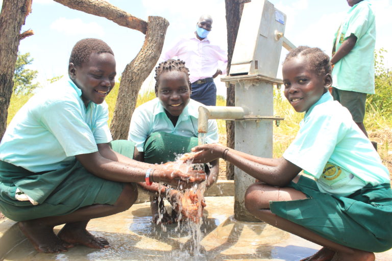 Three girls accessing clean water at the well drilled by Drop in the Bucket for the Wii- Aceng primary school in Omoro, Uganda