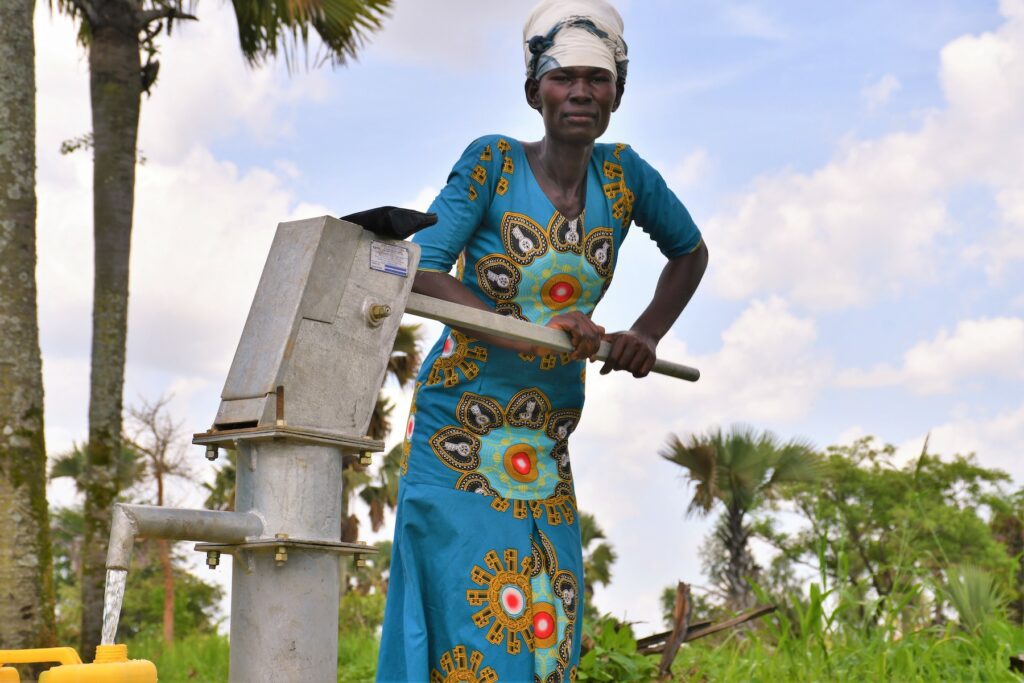 Atoo Jamila using a well drilled by Drop in the Bucket in Layik West Uganda