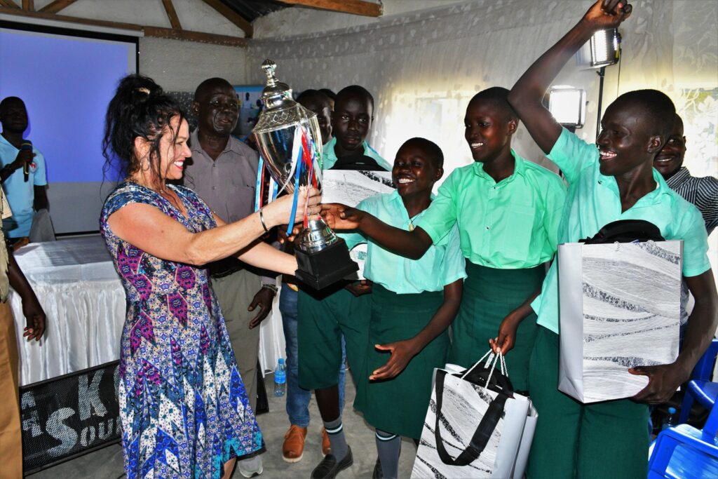 Drop in the Bucket's Director Stacey Travis presents the winning team from Green Valley Primary School in Eastern Equatoria their trophy.