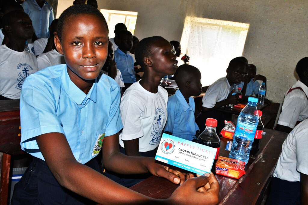 A student holds up her raffle ticket in the Drop in the Bucket South Sudan inter-school quiz competition