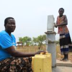 Community members using the new borehole well at the Angole Health Center in Pader, Uganda
