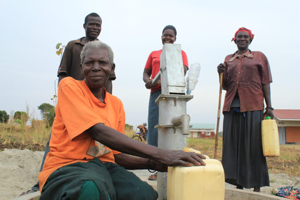 Community members from the Angole parish get water from the well at the Angole health center in Pader, Uganda.