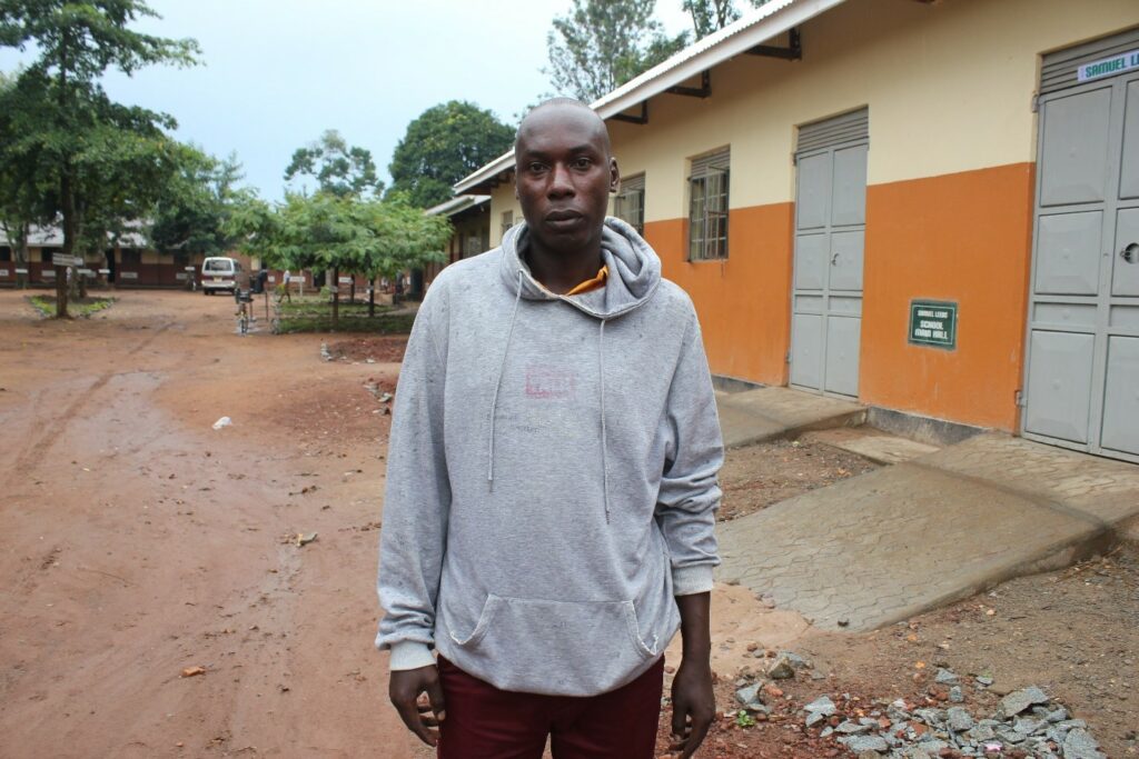 Muhondo Eric, the senior male teacher stands in front of one of the classrooms at Bulubandi primary school in Uganda