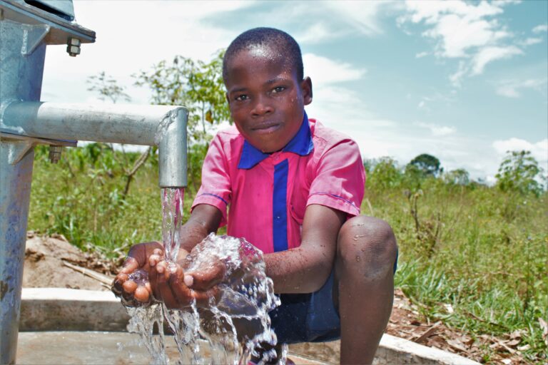 A young boy getting clean water from the new well at Bulumwaki Primary School, Uganda - Drop In the Bucket A young boy gets clean water from the new well at Bulumwaki Primary School in Uganda, drilled by Drop in the Bucket a leading africa water charity