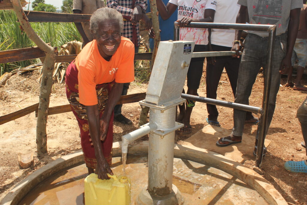 Acan Margaret, a grandmother from Oturuloya Lagwedola village in Uganda, collects clean water at a well drilled by Drop in the Bucket.