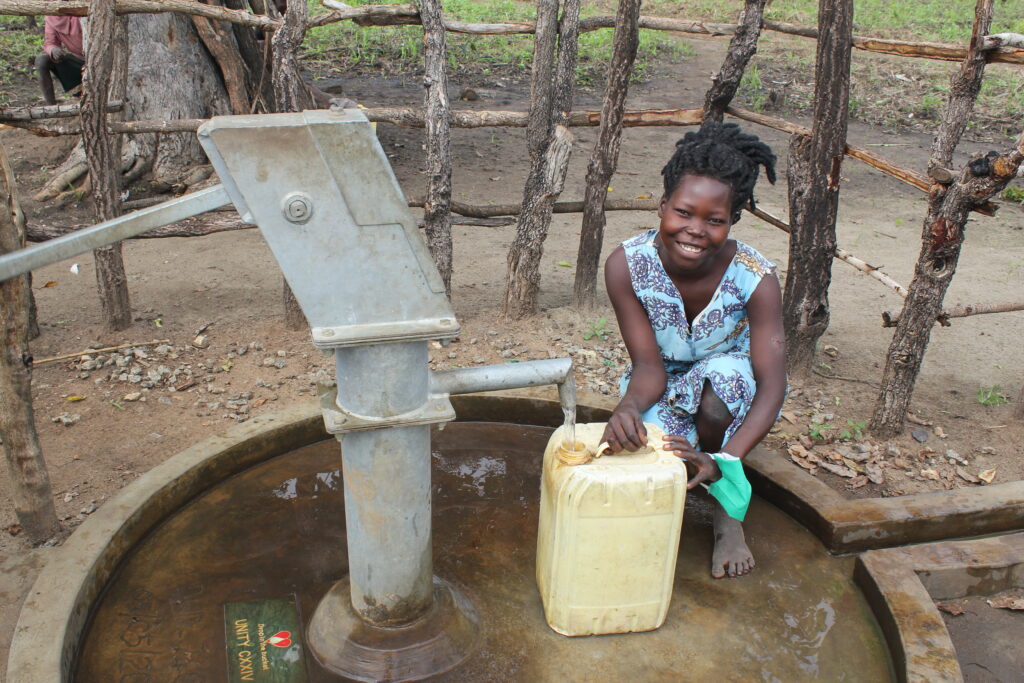 Woman getting clean water from a well in Kampala community, Pader, Uganda, drilled by Drop in the Bucket.