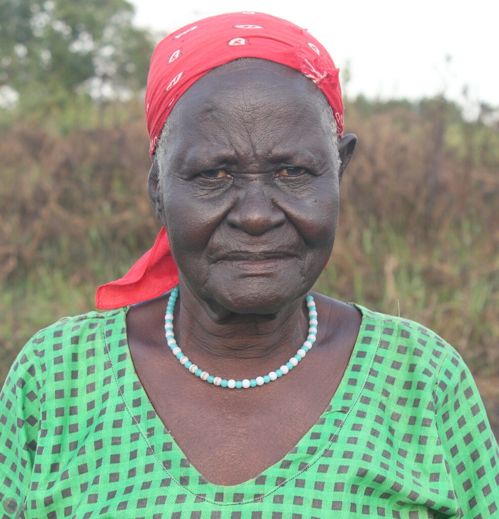Balvina Akullu stands next to a new water well drilled by Drop in the Bucket.