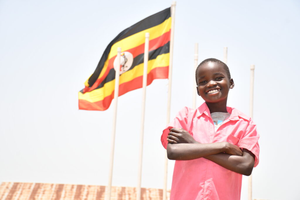 A boy stands by the flag of Uganda at Ongai Primary School in Nwoya, Uganda.