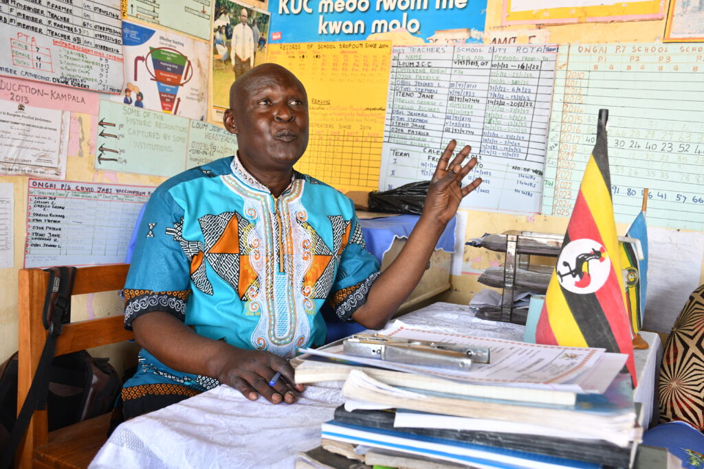 Headteacher Loum Joe Collins Christopher sits behind his desk at the Ongai Primary School in Nwoya, Uganda.