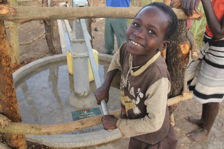 A boy from Lumec village in Uganda gets clean water from a well drilled by Drop in the Bucket