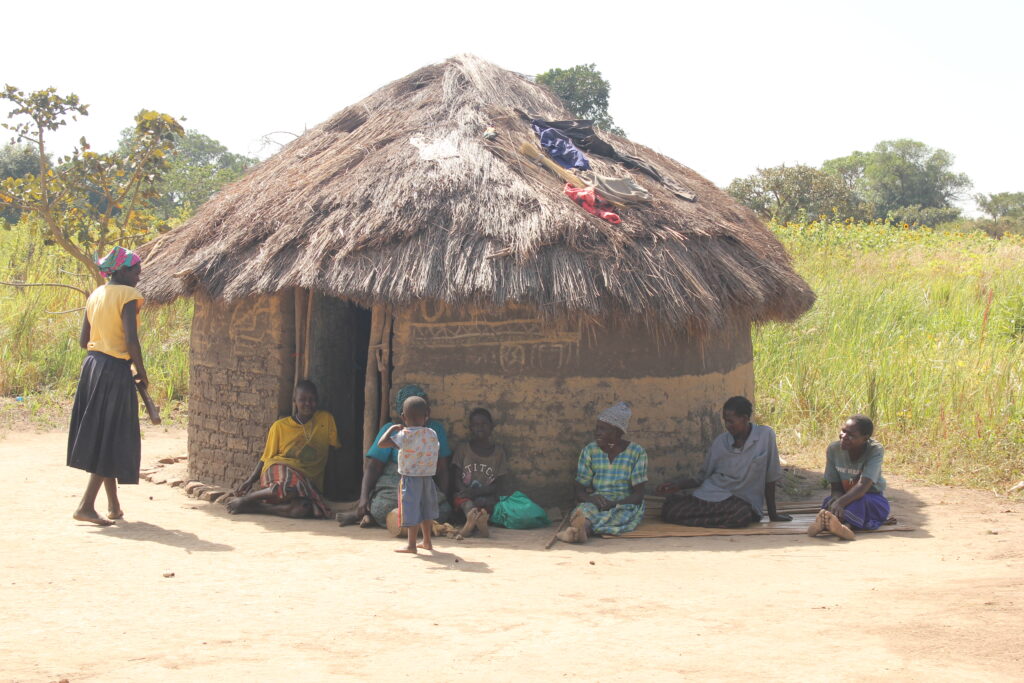 A family stands in front of their traditional hut in Lumec village, Omoro, Uganda, where Drop in the Bucket has provided clean water.