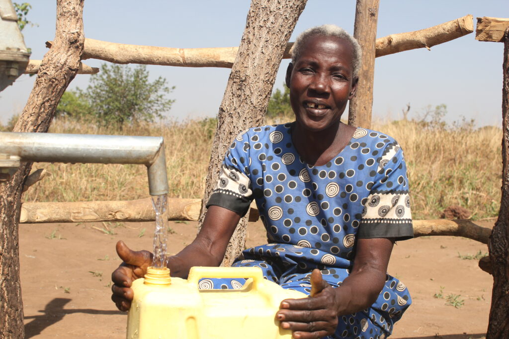 Angom Hellen from the Ngom Rom village in Uganda collects clean water from the well drilled by Drop in the Bucket