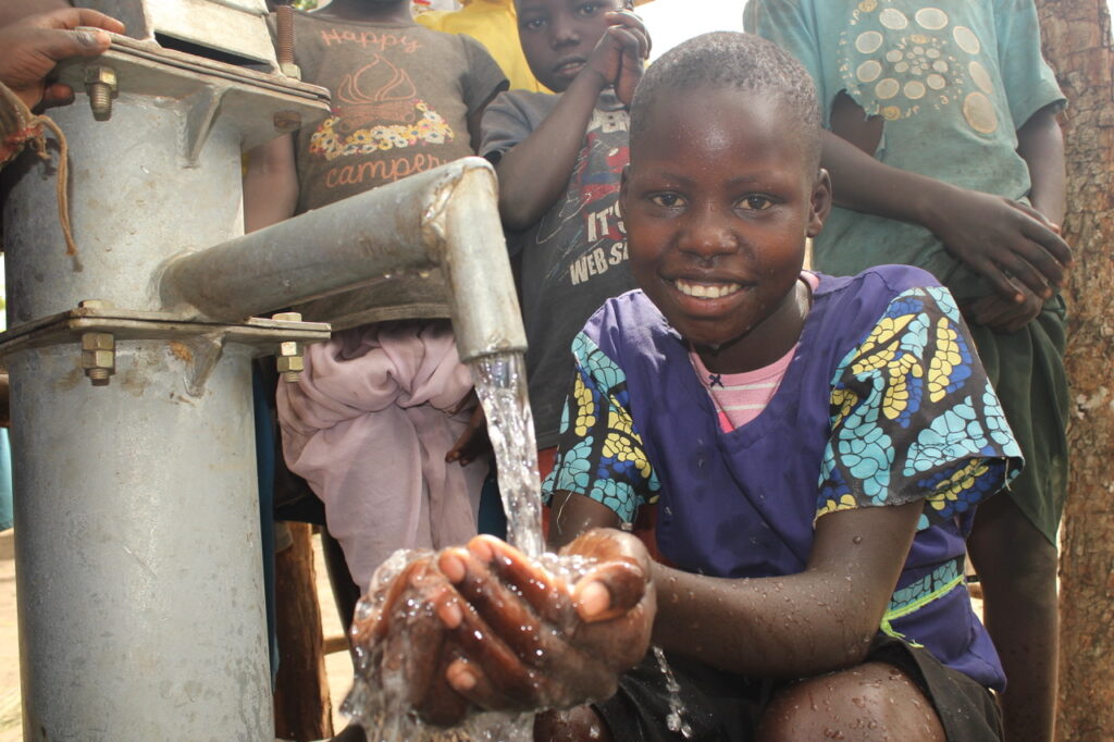 A girl from Laminogwiri village gets clean water from the well drilled by Drop in the Bucket