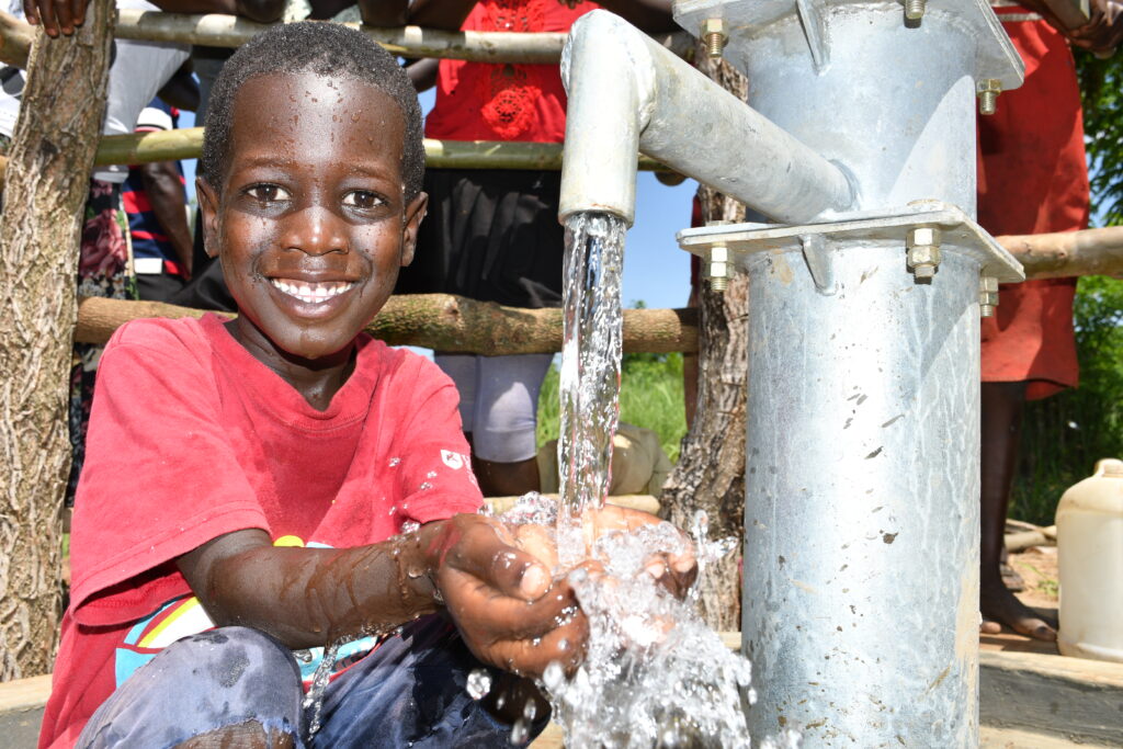 A child collecting clean water from a well drilled by Drop in the Bucket in Gulu District, Uganda.