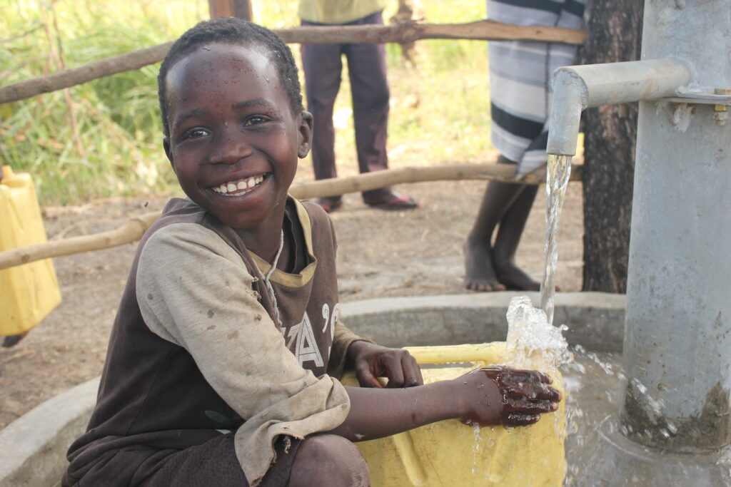 A child drinks clean water from a well in Lumec village, Omoro, Uganda, a project by Drop in the Bucket.