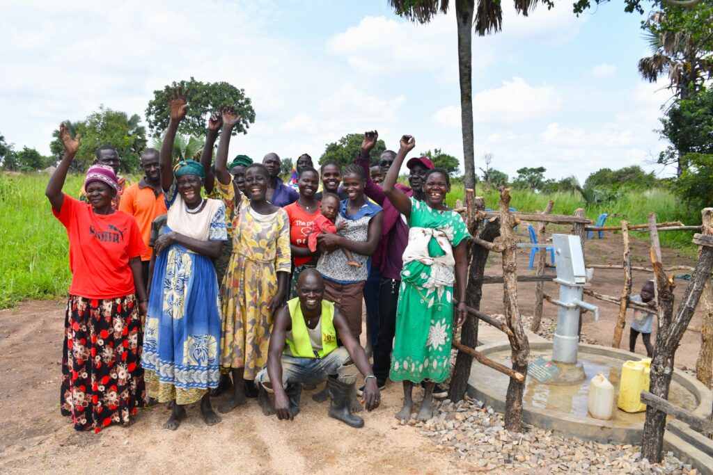 Abegu Villagers Celebrate New Drop in the Bucket Well - Drop In the Bucket Community members in Abegu Village, Gulu District, cheer around a freshly completed Drop in the Bucket clean-water borehole.