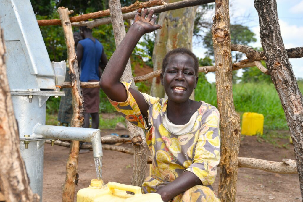 Clean-Water Borehole Empowers Women in Gulu, Uganda - Drop In the Bucket Aryemo Sulima draws clean water from Drop in the Bucket’s new borehole in Abegu Village, Gulu District, northern Uganda.