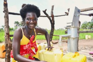Woman fills jerrycan with clean water at Drop in the Bucket borehole in Abegu Village, Gulu District, northern Uganda.