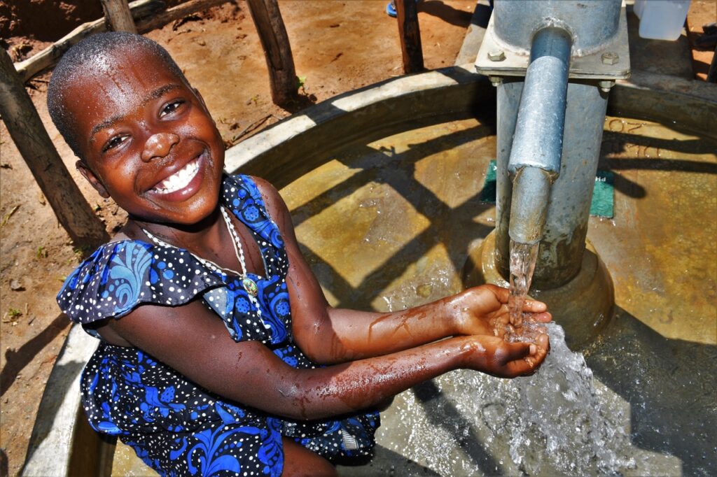 Girl gets clean water from a well in Laliya Dwol in the Gulu District of northern Uganda drilled by Los Angeles clean water charity Drop in the Bucket
