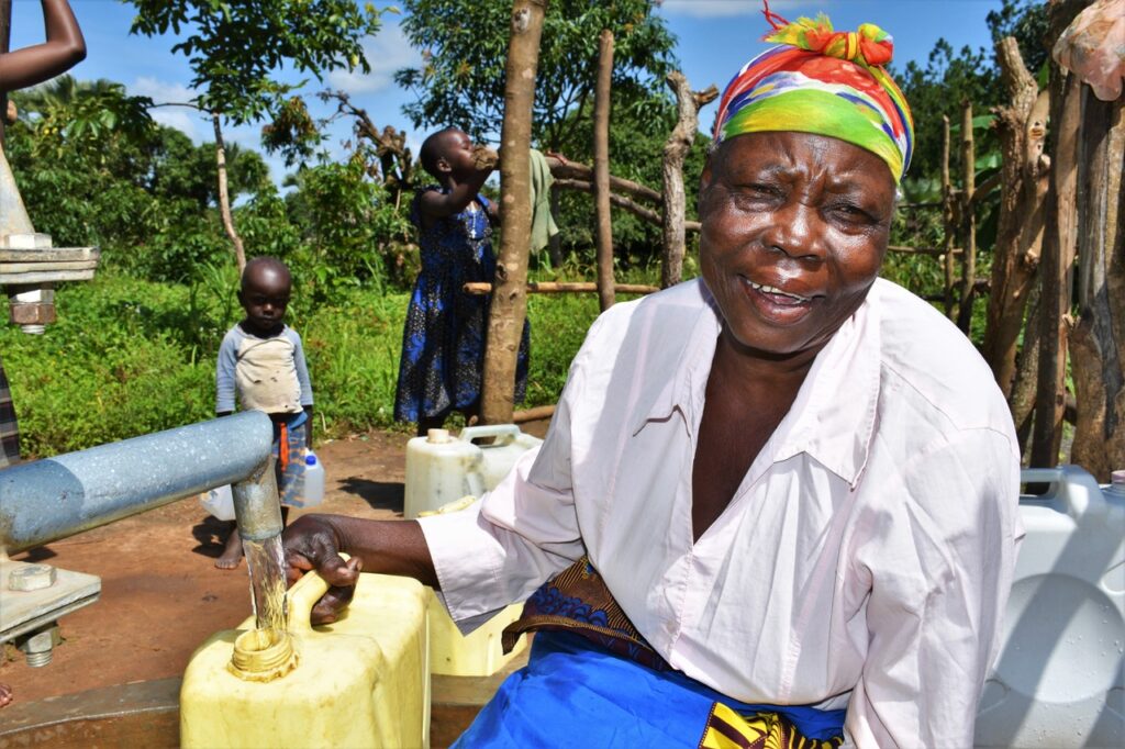A woman in Laliya dwol in Uganda gets clean water from a borehole well drilled by Africa water charity Drop in the Bucket