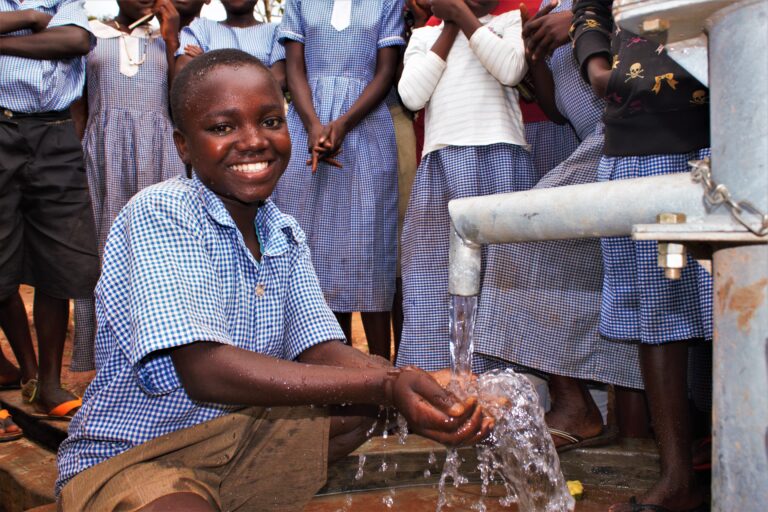 Uganda water wells Buyubu primary - Drop In the Bucket A male student gets clean water from a well at the Buyubu primary school in Iganga, Uganda drilled by Drop in the Bucket