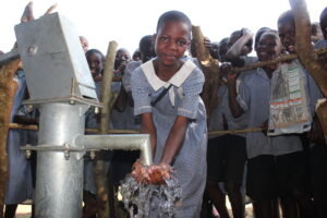 A girl gets clean water from the well at the Nawangisa Primary School in Iganga, Uganda