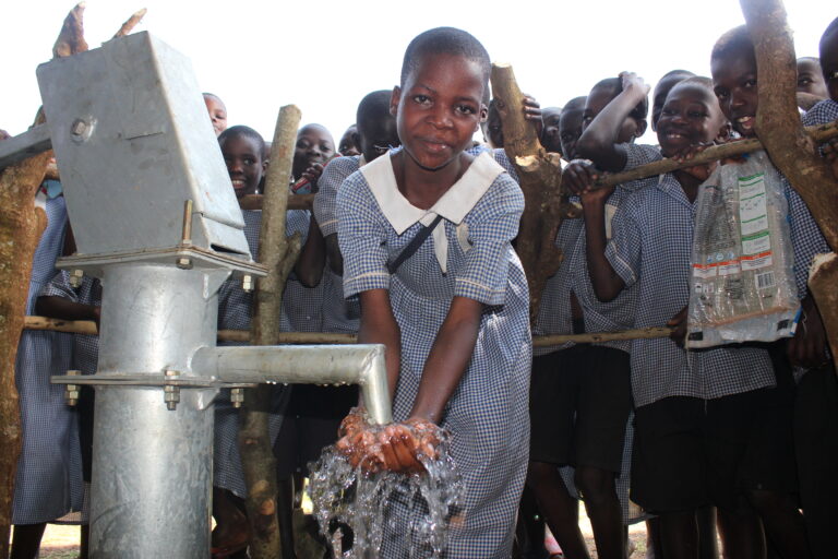 Nawangisa Primary School Iganga Uganda - Drop In the Bucket A girl gets clean water from the well at the Nawangisa Primary School in Iganga, Uganda