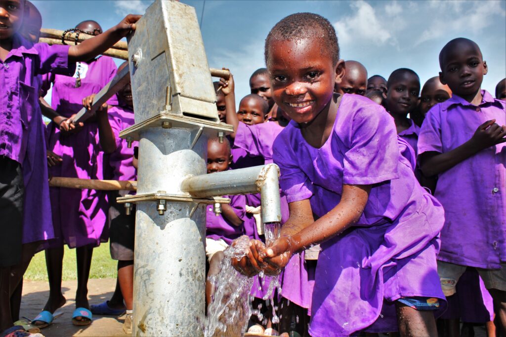 Bukwaya Primary School and Health Center II Imanyiro Uganda - Drop In the Bucket A student gets clean water from the well at the Bukwaya Primary School in Imanyiro, Uganda.