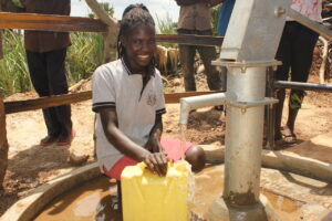 A woman gets clean water from the well at Oturuloya Lagwedola in Gulu, Uganda