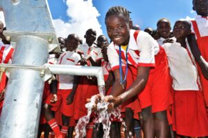 A girl gets clean water from the well at the Princess Royal Primary School in Gulu, Uganda