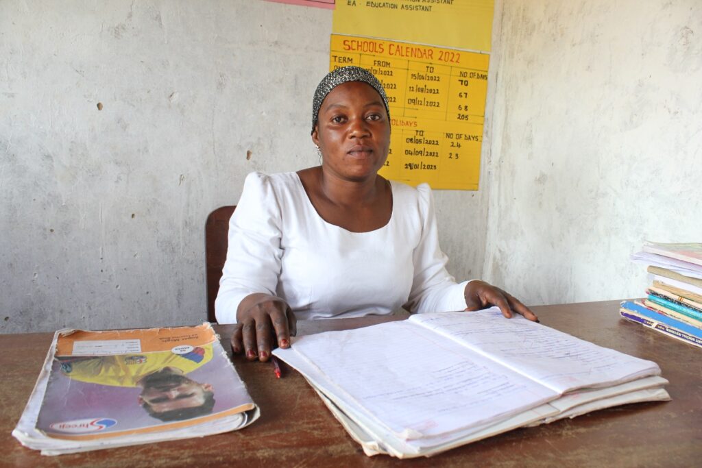 Nawongobi Zamina Bukwaya Primary School. - Drop In the Bucket Nawongobi Zamina, deputy head teacher for the Bukwaya Primary School in Imanyiro , Uganda sits by the desk in her office