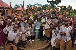 Students at the Bulubandi primary school in Iganga, Uganda celebrate the new well drilled by Drop in the Bucket