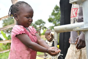 Drop in the Bucket Uganda water wells- Paminano-A Cell village. - Drop In the Bucket A Ugandan girl gets safe water from a borehole well drilled in Paminano-A Cell village.