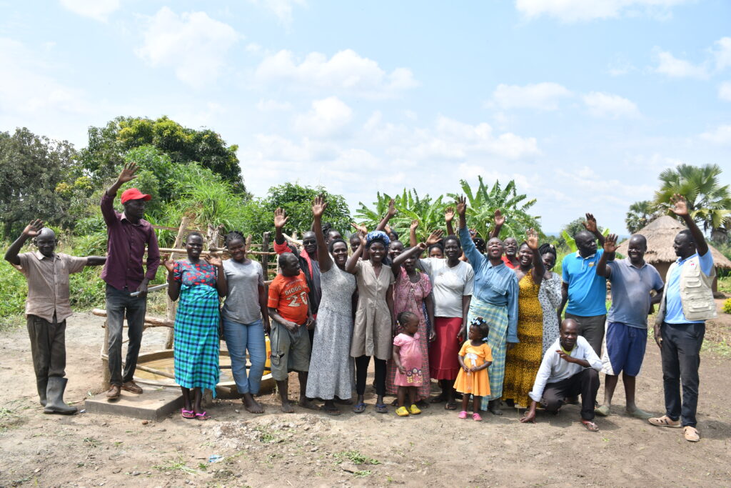 Community members of Paminano Cell A community in Uganda by the new water well that Drop in the Bucket drilled.