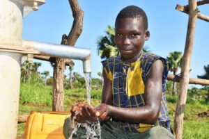 A child getting clean water from the well at Layik West in Kitgum, Uganda