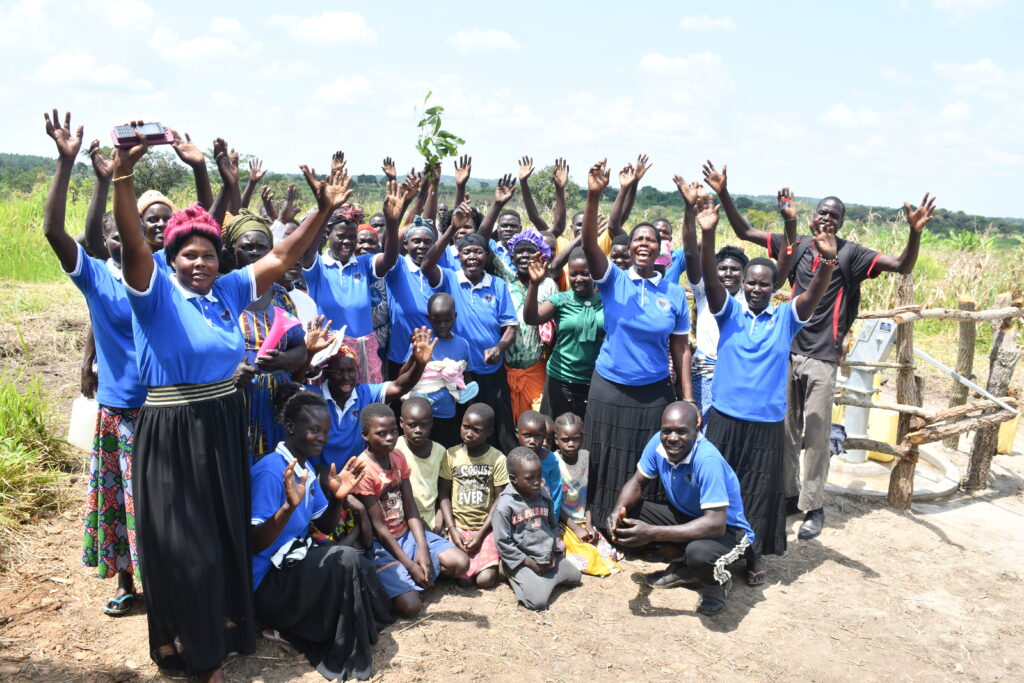 An excited waving crowd of happy community members from Lakwatomer village in northern Uganda