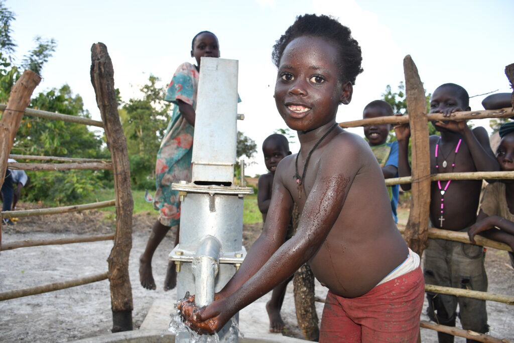 A boy from the from Bidin B village in Nwoya gets clean water from a well in the village.
